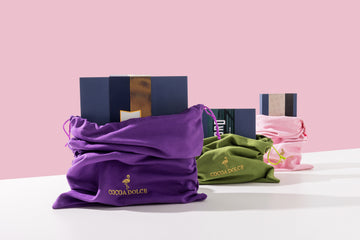 Cocoa Dolce corporate chocolate gifts in purple, green, and pink embroidered velvet gift bags with navy gift boxes