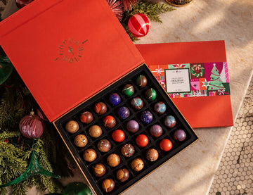 Cocoa Dolce Holiday Collection gift box with assorted luxury chocolates in festive red packaging.