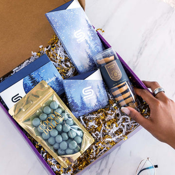 A custom branded Cocoa Dolce corporate gift box with a company-branded card, gold velvet bag, and chocolate bar.
