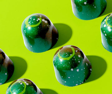 Close-up of pistachio-filled Dubai chocolate bites on a green background